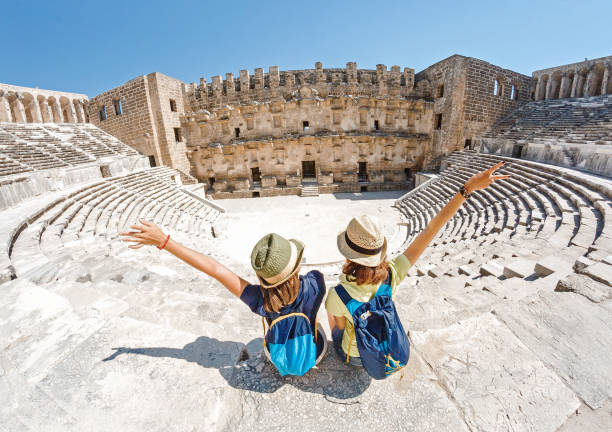 dos jóvenes estudiantes de viajero disfrutan de un recorrido por el antiguo anfiteatro griego - amphitheater fotografías e imágenes de stock