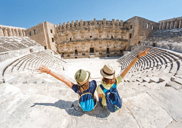Two young girls student traveler enjoy a tour of the ancient Greek amphitheater Two young girls student traveler enjoy a tour of the ancient Greek amphitheater greece travel stock pictures, royalty-free photos & images
