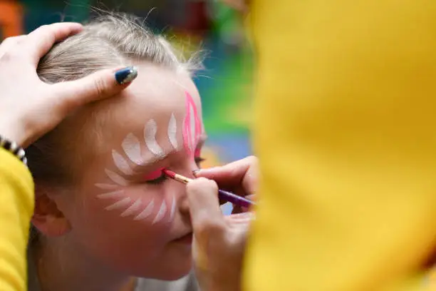 Animator draws a girl drawing on the face at a party.