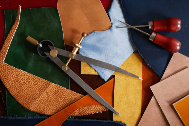 Leatherwork Background Background image of leather cuts and tools scattered on table in tanners workshop, copy space atelier fashion photos stock pictures, royalty-free photos & images