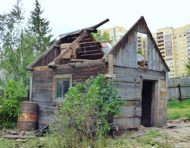 istock Small aged damaged house against modern high-rise buildings 1146297700