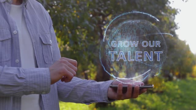 Man shows hologram with text Grow our talent