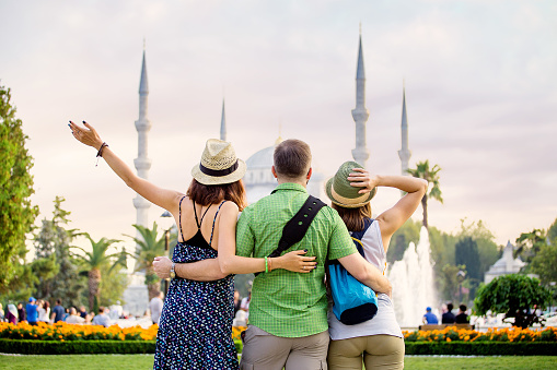 Group of Friends hugging and looking at Istanbul great Blue Mosque. Student travel in Turkey concept