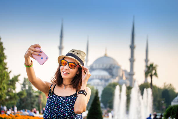 Happy woman in hat and sunglasses making selfie by the smartphone on the background of the Blue Mosque, Istanbul, Travel and vacation in Turkey concept Happy woman in hat and sunglasses making selfie by the smartphone on the background of the Blue Mosque, Istanbul, Travel and vacation in Turkey concept istanbul photos stock pictures, royalty-free photos & images