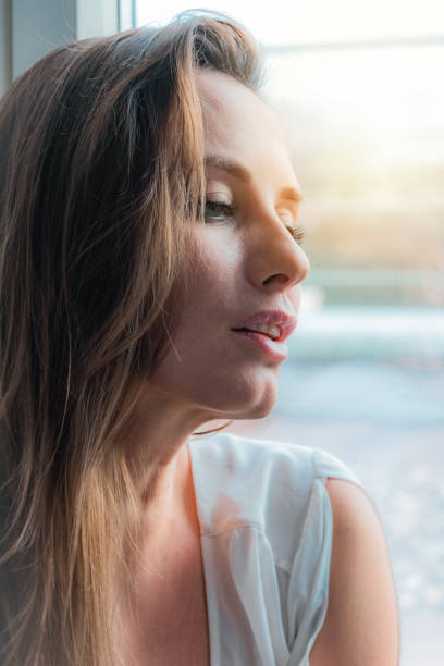 istock pretty woman portrait at the window 1146299626