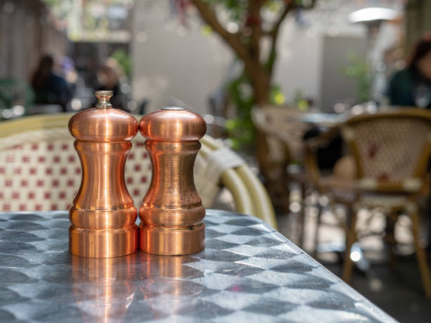 istock Cooper salt and pepper shakers and grinders sitting outdoors on  restaurant table 1146301745