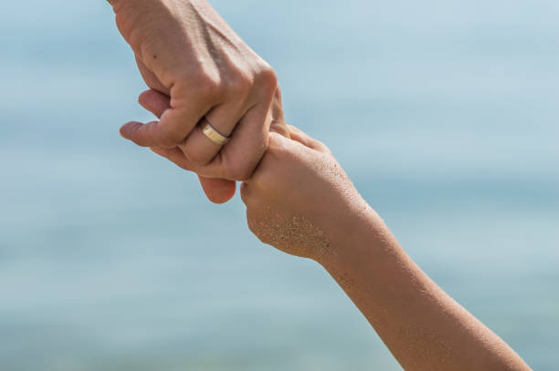 istock Mother holding hands of her daughter 1146304124