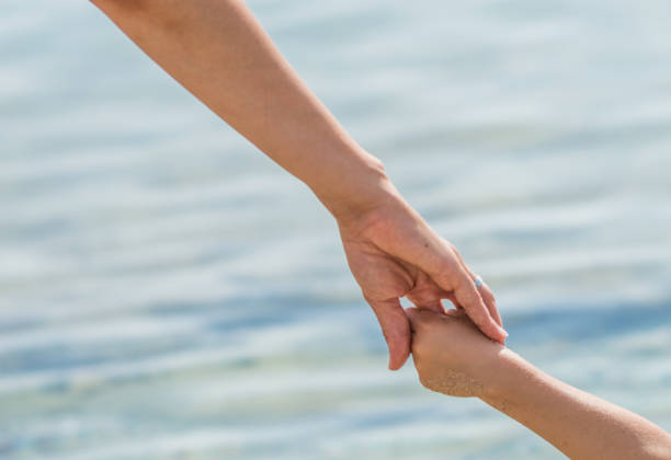 istock Mother holding hands of her daughter 1146304232