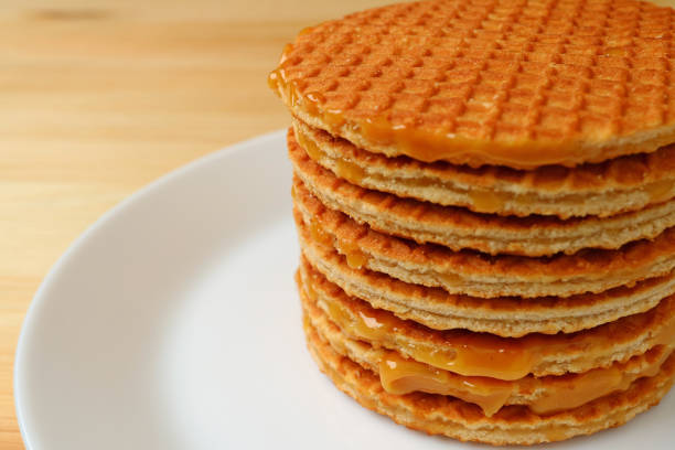 Stack of Mouthwatering Stroopwafels on the White Plate Served on Wooden Table