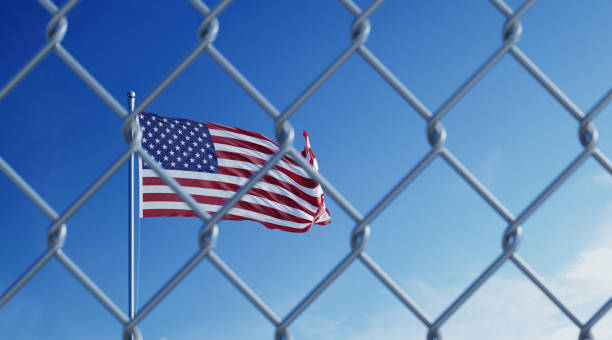 Fence In Front Of American Flag Fence in front of American flag. Illegal immigration concept. Horizontal composition with copy space. department of homeland security stock pictures, royalty-free photos & images