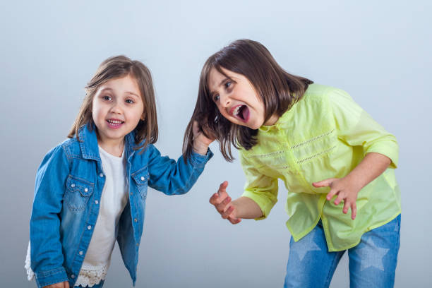 istock conflict between sisters, younger sister pulls the hair older sister 1146308688