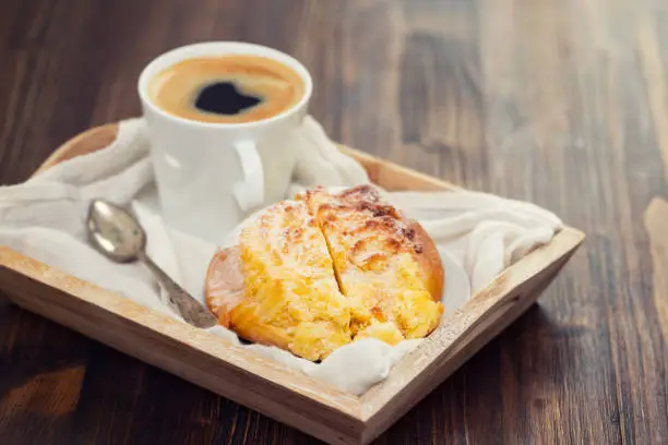Photo of portuguese sweet bread pao de deus with cup of coffee