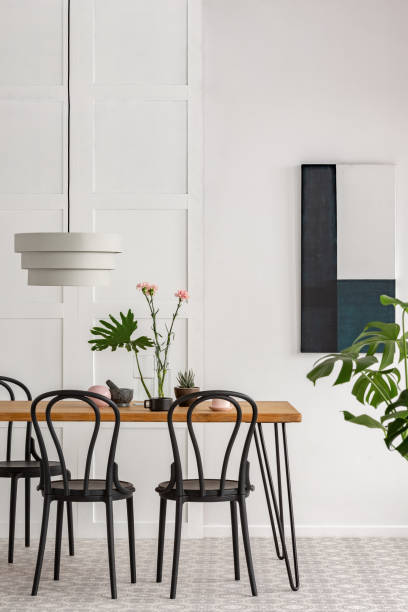 istock White lamp above wooden table with black chairs 1146313926
