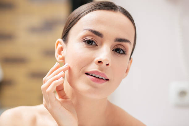 istock Dreamy lady touching her skin and looking interested 1146314106