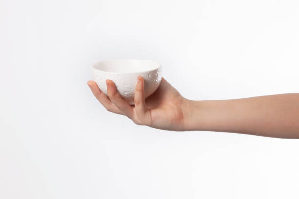 istock Porcelain dish bowl in hand isolated on white background 1146315278