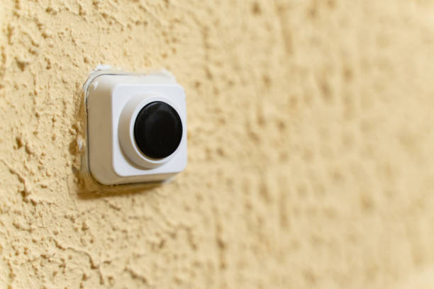 istock black doorbell button in white case on yellow wall with embossed texture 1146316478