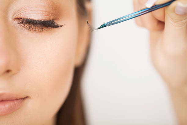 istock Eyelashes extensions. Fake Eyelashes. Eyelash Extension Procedure. Professional stylist lengthening female lashes. Master and a client in a beauty salon 1146348641