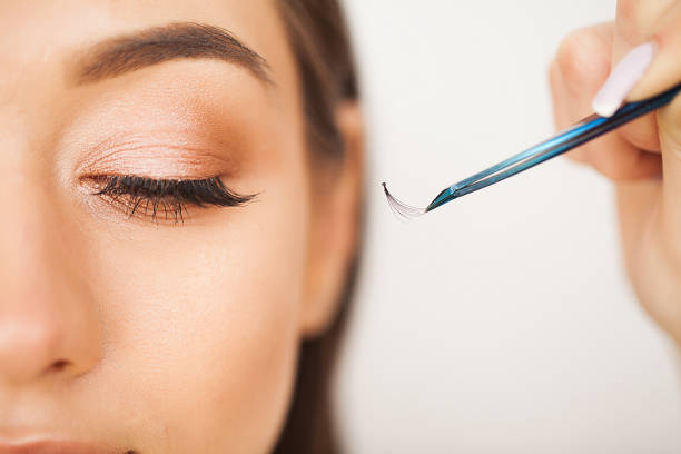 istock Eyelashes extensions. Fake Eyelashes. Eyelash Extension Procedure. Professional stylist lengthening female lashes. Master and a client in a beauty salon 1146348687