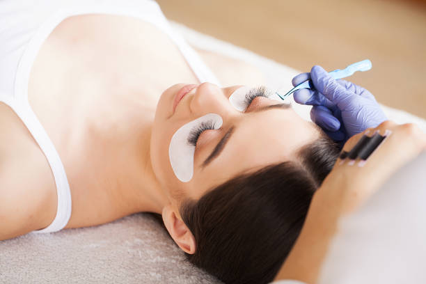 istock Eyelashes extensions. Fake Eyelashes. Eyelash Extension Procedure. Professional stylist lengthening female lashes. Master and a client in a beauty salon 1146348769