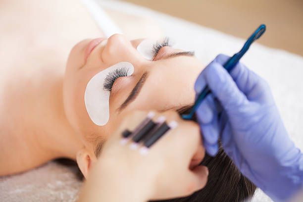 istock Eyelashes extensions. Fake Eyelashes. Eyelash Extension Procedure. Professional stylist lengthening female lashes. Master and a client in a beauty salon 1146349756