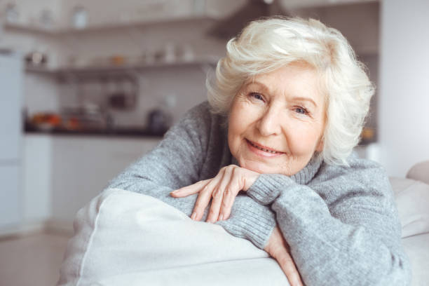Portrait of grandmother in gray sweater. Dreaming, wondering concept stock photo