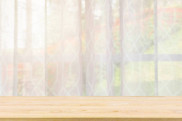 istock Empty wood table top with window curtain abstract blur background for product display 1146354829