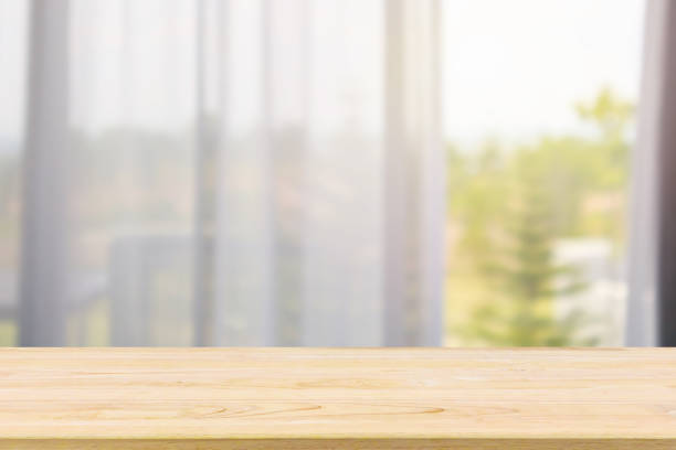 istock Empty wood table top with window curtain abstract blur background for product display 1146354832