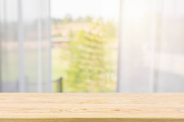 istock Empty wood table top with window curtain abstract blur background for product display 1146354833