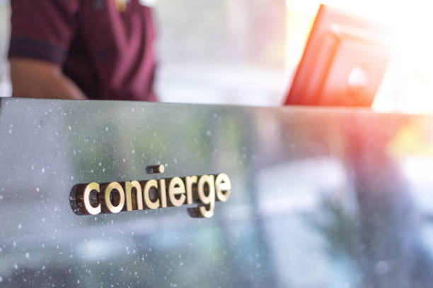 Concierge service desk counter with staff team working in front of hotel with tourist business customer. Concierge service desk counter with staff team working in front of hotel with tourist business customer. bellhop photos stock pictures, royalty-free photos & images