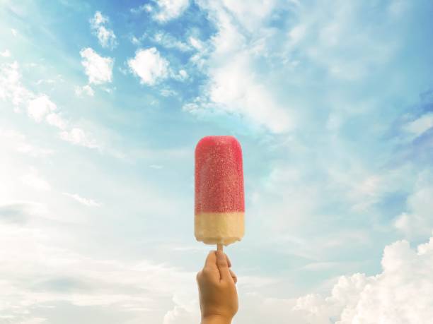 Pink ice cream in hand and beautiful blue cloudy sky