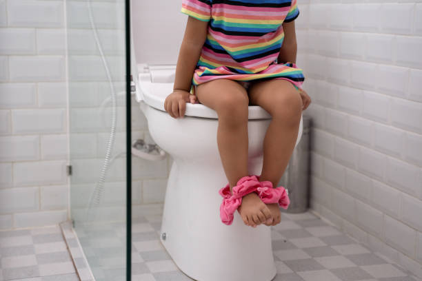 istock toddler's feed while sitting on toilet with pants down 1146361804