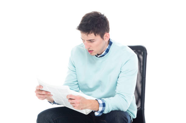 istock Handsome young man sitting and reading a document in a serious manner 1146366132