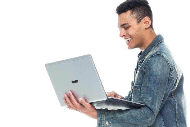 istock Good looking tall black man wearing denim jacket - using a laptop 1146366909