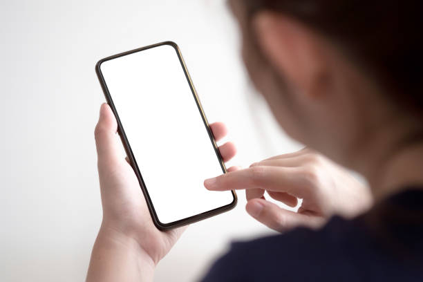 istock Woman hands using smartphone mockup at the white office desk. Blank screen mobile phone for graphic display montage 1146397224