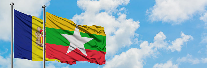 Andorra and Myanmar flag waving in the wind against white cloudy blue sky together. Diplomacy concept, international relations.