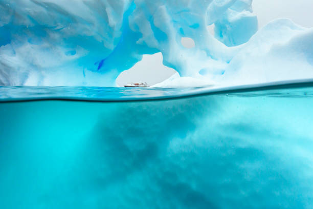 A ship seen through a hole in an Iceberg in the ocean of Errera Channel, Antarctic Peninsula