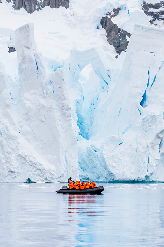 A group of ship passengers explore the ocean and visit a glacier up close by Zodiac in Paradise Harbor on the Antarctic Peninsula