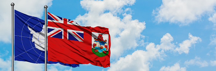 Antarctica and Bermuda flag waving in the wind against white cloudy blue sky together. Diplomacy concept, international relations.