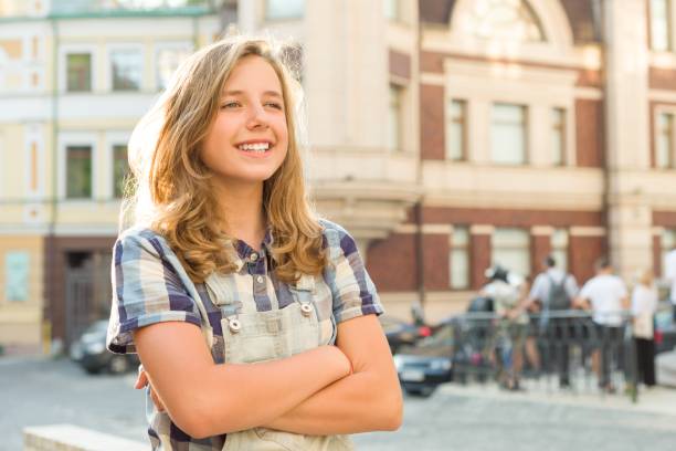 outdoor portrait of smiling teenager girl 12, 13 years old on city street, girl with folded hands, copy space - years 13 14 years teenager old imagens e fotografias de stock