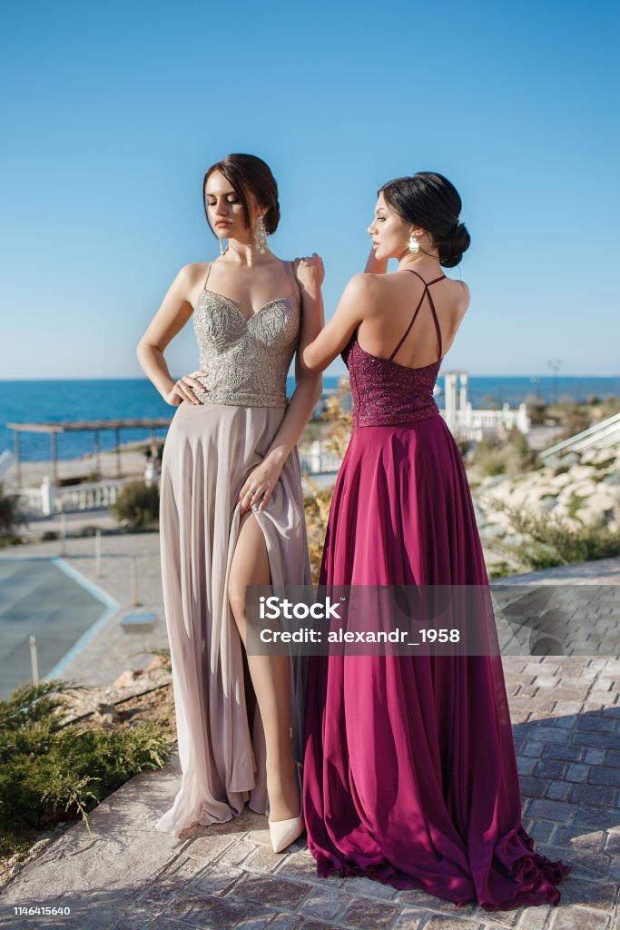 Dos Hermosas Mujeres Modelos Demuestran Vestidos De Noche Para Eventos Foto  de stock y más banco de imágenes de A la moda - iStock