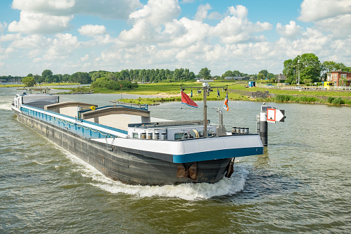 Barge freight ship passing the elevated city bridge over the river IJssel in Kampen, Overijssel, The Netherlands.