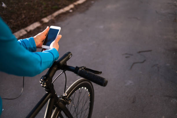 istock Senior sportswoman using her smart phone on bicycle 1146421253