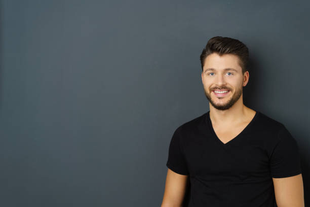 istock Young bearded cheerful man on black background 1146429738
