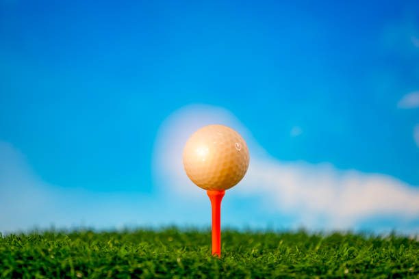 istock Golf ball on tee in tee off zone on grass and blue sky and cloud background 1146429759