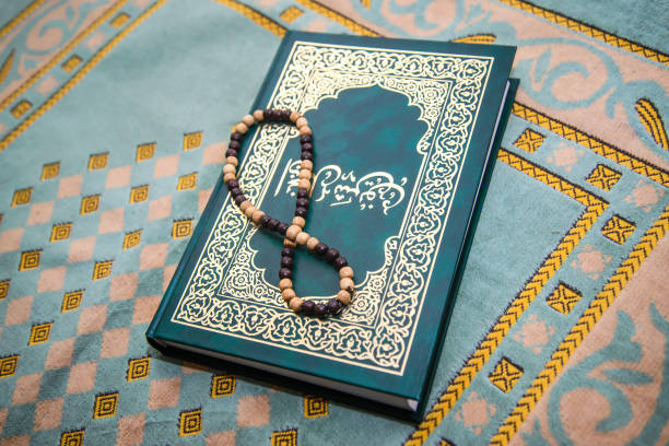 Muslim rosary and prayer book on green rug, Ramadan