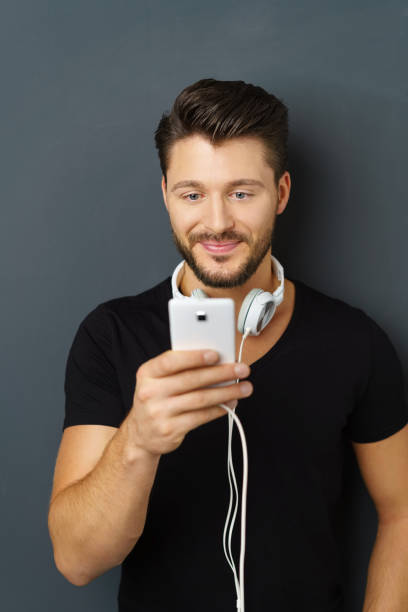 istock Young bearded man with headphones using smartphone 1146433086