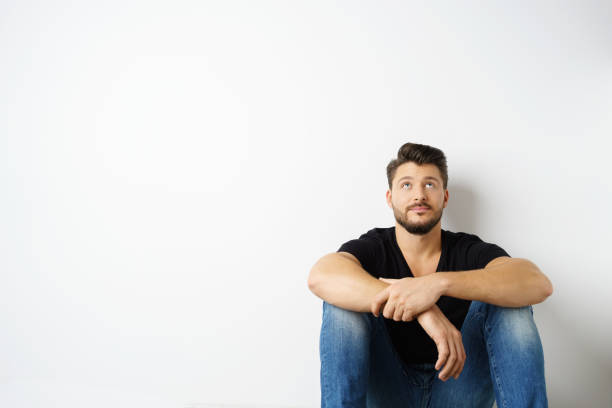 istock Contemplating man sitting on floor 1146433308