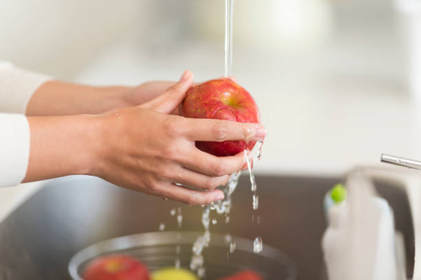 istock Housewife washing apple with water 1146433569