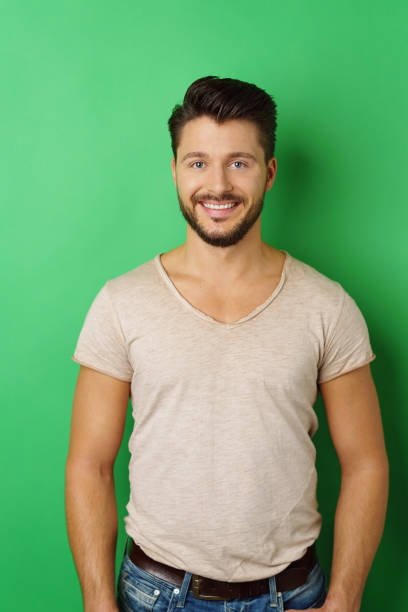 istock Smiling young man posing against green background 1146435845