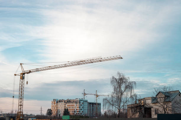 istock Yellow high tower cranes building house at sunset 1146443771